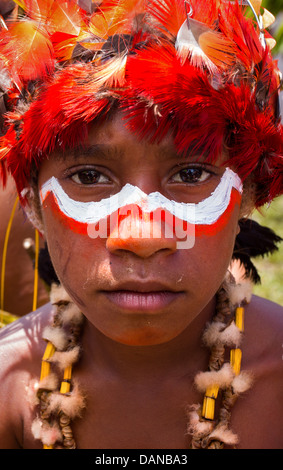 Kleiner Junge mit seinem Gesicht bemalt und tragen einen Stammes-Kopfschmuck in Goroka Show im Hochland von Papua-Neu-Guinea. Stockfoto