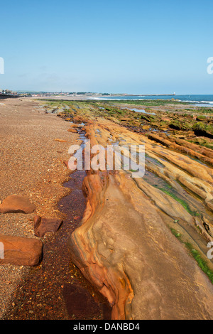 Spittal Strand Sandstein Gesteinsschichten bedeckt in Eisenerz. Spittal, Berwick nach Tweed, Northumberland, England Stockfoto