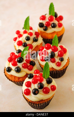 Cupcakes mit Mascarpone und Waldbeeren. Rezept zur Verfügung. Stockfoto