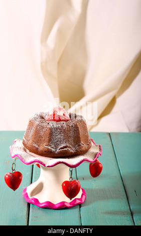 Zitrone Vanille Mini lbs (Bundt)-Kuchen mit Erdbeeren und Puderzucker auf antiken Stand mit roten Herzen auf rustikalen Tisch Stockfoto