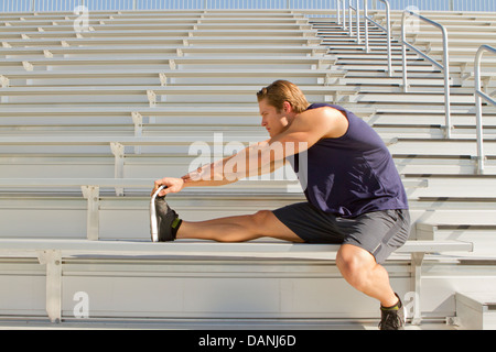 Ein kaukasischer Mann in seinen Zwanzigern klappt in einem Stadion. Stockfoto