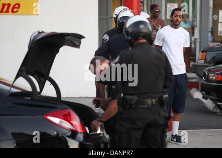 Los Angeles, CA, USA. 16. Juli 2013. Polizei durchsuchen den Kofferraum Rapper Nipsey Hustle Autos. Hektik war von der Polizei in Leimert Park nach angeblich schwingt eine Waffe, die nicht am Tatort gefunden wurde gestoppt. Polizei durchsucht sein Auto, ein Messer gefunden und verhaftet ihn. Es waren ca. 15-20 Polizei Autos und Motorräder am Tatort. Die Verhaftung trat als Proteste über Zimmerman Freispruch im Leimert Park inmitten starker Polizeipräsenz fortgesetzt. Bildnachweis: Krista Kennell/ZUMAPRESS.com/Alamy Live-Nachrichten Stockfoto