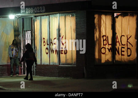 Los Angeles, CA, USA. 16. Juli 2013. Die Menschen gehen vorbei an einem Geschäft im Crenshaw Blvd mit der Aufschrift "Schwarz-Besitz" in den Fenstern. Proteste gegen Zimmerman Freispruch im Leimert Park inmitten starker Polizeipräsenz fortgesetzt. Am Vorabend einer vagabundierenden Bande von Menschen Geschäfte geplündert und überfallen Menschen auf Crenshaw Blvd. Kredit: Krista Kennell/ZUMAPRESS.com/Alamy Live News Stockfoto