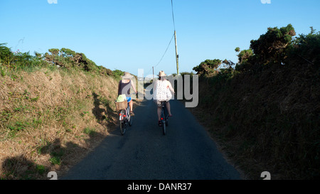 Zwei junge Frauen, die an einem frühen Sommerabend in St. Davids Pembrokeshire Wales, Großbritannien, AUF einer Fahrspur radeln, KATHY DEWITT Stockfoto