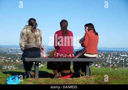 Freunde saß auf einer Bank auf dem Gipfel Mount Eden, Auckland, Neuseeland. Stockfoto