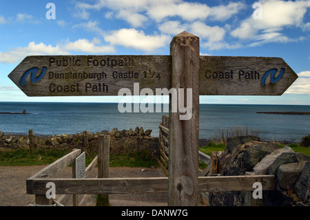 Wegweiser aus Holz Dunstanburgh Castle von Craster auf St. Oswald Weise lange Entfernung Fußweg Northumberland Küste Stockfoto