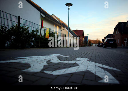 (DATEI) Eine Archivfoto datiert 27. Januar 2011 zeigt ein Verkehrsschild, gemalt auf der Straße vor dem Haus des Verdächtigen verhaftet Mirco Fall, Signalisierung spielende Kinder in Ungerath, Deutschland. Die Testversion in die Ermordung von Mirco beginnt am 12. Juli 2011. Foto: Oliver Berg Stockfoto