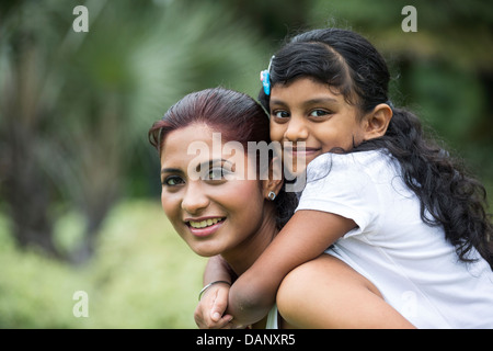 Glückliche indische Mutter und Tochter spielen im Park. Lifestyle-Bild. Stockfoto