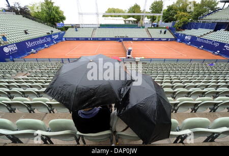 Zwei Fans sitzen unter Sonnenschirmen, während sie, das Finale des ATP-Turniers am Weißenhof in Stuttgart, Deutschland, 17. Juli 2011 warten. Aufgrund anhaltender Regenduschen ist das Finale vorübergehend verschoben. Foto: Bernd Weissbrod Stockfoto