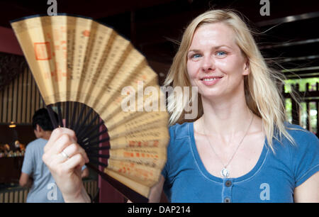 Das Bild machte zugänglich 20. Juli 2011 zeigt deutsche Schwimmerin Britta Steffen schmeichelhaft ein Fan während eines Besuchs des Cheng Huang Miao Tempels im Yu Garten vor den FINA Schwimmweltmeisterschaften 2011 in Shanghai, China, 18. Juli 2011. Foto: Bernd Thissen dpa Stockfoto