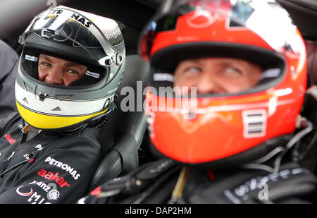 Deutsche Formel1-Fahrer Nico Rosberg (L) und Teamkollege Michael Schumacher Mercedes GP sitzen in einem Mercedes-Benz C63 AMG auf der alten Rennstrecke verfolgen "Nordschleife" an der F1 Rennstrecke Nürburgring, Nuerburg, 21. Juli 2011. Die Formel 1 Grand Prix von Deutschland statt findet am 24. Juli. Foto: Jan Woitas Dpa/Lrs +++(c) Dpa - Bildfunk +++ Stockfoto