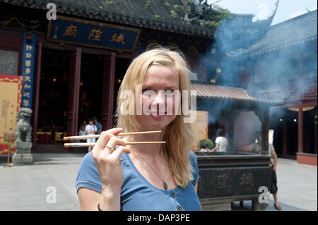 Deutsche Schwimmerin Britta Steffen ist mit einem chinesischen Stäbchen während eines Besuchs für einen Bericht von der ARD-Sportschau in der Yu-Garten vor den FINA Schwimmweltmeisterschaften 2011 in Shanghai, China, 18. Juli 2011 gesehen. Foto: Bernd Thissen dpa Stockfoto