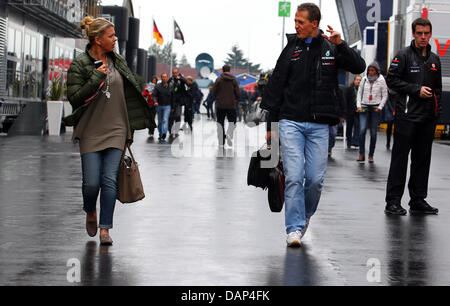 Deutsche Formel1 Rennfahrer Michael Schumacher Mercedes GP geht mit seiner Frau Corinna durch das Fahrerlager vor der Formel 1 Grand Prix von Deutschland beim F1 Rennen verfolgen der Nürburgring, Nuerburg, Deutschland, 24. Juli 2011. Foto: Jens Büttner Dpa/lrs Stockfoto