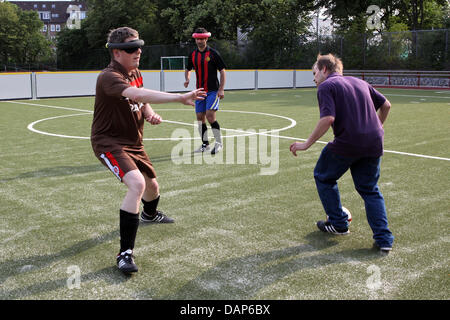 Die blinde Kicker, die, der Michael Meyer (r) den Ball während der blinde Fußball-Praxis des FC St. Pauli auf dem Sportplatz des Bildungszentrums für spielt, Jalousien und blinde und Sehbehinderte in Hamburg, Deutschland, 12. Juli 2011. Die blinde und sehbehinderte Menschen Kicker des FC St. Pauli sind Teil der blinde Fußball-Bundesliga und kämpfen um die Meisterschaft mit acht anderen Teams. Foto: Bodo Marks Stockfoto