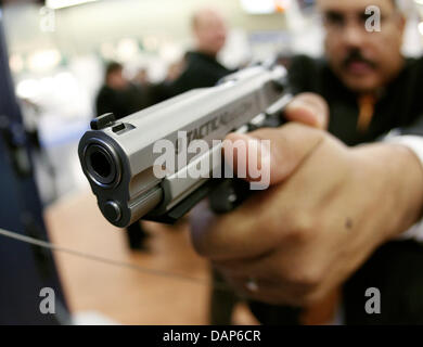 Datei - eine Archiv-Bild vom 13. März 2009 ein Mitarbeiter von dem amerikanischen Hersteller Smith & Wesson, zeigt ein 9-mm-Handfeuerwaffe in den Händen hält, während die Waffen Messe IWA 2009 in Nürnberg.  Nach die Anschlägen in Norwegen die Forderung nach Stärkung des Waffengesetzes wächst lauter in Deutschland. Foto: Daniel Karmann Stockfoto