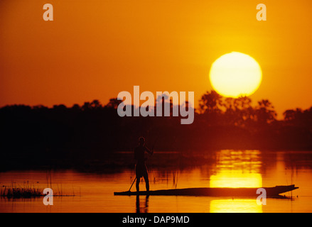 Sonnenuntergang mit einem Poler und Makoro im Okavangodelta, Botswana Stockfoto