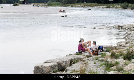 Ein paar sitzt am Ufer des Flusses renaturierte Isar in München, 3. August 2011. Nach elf Jahren Bauzeit wurde die Renaturierung der acht Kilometer langen Abschnitt abgeschlossen. Foto: Tobias Hase Stockfoto