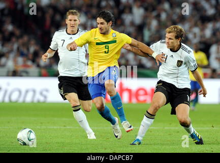 Brasilianischer Spieler Alexandre Pato (C) wetteifert um den Ball mit Bastian Schweinsteiger (L) und Holger Badstuber (R) Deutschlands während das Freundschaftsspiel Deutschland gegen Brasilien in der Mercedes-Benz Arena in Stuttgart, Deutschland, 10. August 2011. Foto: Bernd Weissbrod Stockfoto