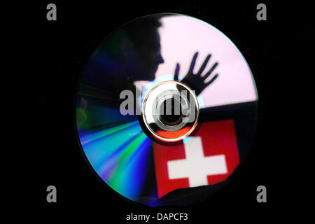 Datei - ILLUSTRATION - eine Archiv Bild 2. Februar 2010 datiert zeigt die Silhouette eines Mannes und einer Schweizer Flagge, eine CD in Düsseldorf reflektiert wird. Kurz nachdem der Deutsch-Schweizer Abkommen Steuer verursacht eine neue CD mit Informationen über mutmaßliche Steuerbetrüger einige Turbulenzen. Foto: Julian Stratenschulte Stockfoto