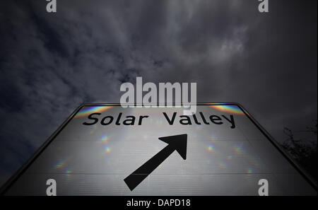 Dunkle Wolken stehen über dem Schild "Solar Valley" an der Autobahn A14 in der Nähe von Bitterfeld-Wolfen, Deutschland, 12. August 2011. Der Aufsichtsrat der geschwächten Solarunternehmen Q-Cells stimmt immer noch nicht über die Höhe der möglichen Stellenabbau. Zum gleichen Zeitpunkt bestätigt Aufsichtsrat Manager Cen Standort Bitterfeld-Wolfen. Durch die Kombination von Forschung und Entwicklung, Produktion Stockfoto