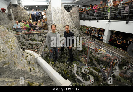 Die Brüder Frederik (R) und Gerrit Braun, Gründer und Geschäftsführer der "Miniatur Wunderland", stehen inmitten einer Modell-Eisenbahn-Landschaft von Schweiz in Hamburg, Deutschland, 12. August 2011. Am 16. August 2011 sieht die Modell-Eisenbahn-Ausstellung "Miniatur Wunderland" sein 10-jähriges Jubiläum, da es am 16. August 2001 eröffnet wurde. Rund 8,3 Millionen Besucher haben die Welt besucht. Stockfoto