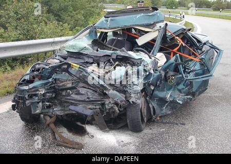 Ein völlig zerstörtes Auto sitzt auf Autobahn A23 nach einem schweren Verkehrsunfall in der Nähe von Heide, Deutschland, 11. August 2011. Ca. 15:00, ein Fahrer schneller als 200 km/h verursachte Unfall in der Nähe Kreuzung Heide verklagt. Mindestens vier Personen wurden verletzt, so ein Polizeisprecher. Foto: Wolfgang Runge Stockfoto