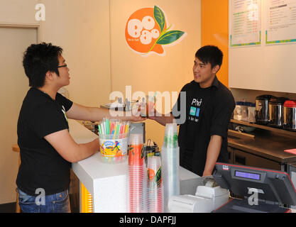 Ein junger Mann kauft die neueste Kult Getränk Bubble Tea oder Luftblase Milchtee im "Tee & Café BoboQ" Store am Alexanderplatz in Berlin, Deutschland, 17. August 2011. Das Geheimnis um die ursprünglich asiatische Mischung aus grünen oder schwarzen Tee mit Milch oder Joghurt und Obst Sirup sind die unterschiedlich aromatisierten Luftblasen aus Stärke gewonnen. Bereits in den USA sehr beliebt, Bubble Tea findet mehr und mehr fans Stockfoto