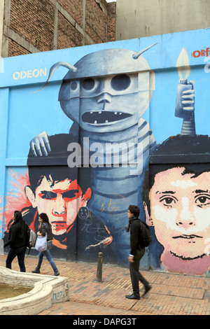 Fußgänger zu Fuß vorbei an Straßenkunst Graffiti Wandmalerei in La Candelaria Barrio von Bogota, Kolumbien. Stockfoto