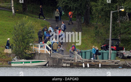 Überlebenden des Massakers Utoya kommen auf einem Schiff auf der Insel Utoya, Norwegen, 20. August 2011. Vier Wochen nach der Bombenexplosion in Oslo und dem folgenden Massaker in einem Ferienlager auf der Insel Utoya Norwegen erinnert an die 77 Opfer des Angriffs mit einer dreitägigen Trauerfeier. Foto: Hannibal Hanschke Stockfoto