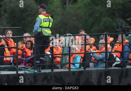 Überlebenden des Massakers Utoya kommen auf einem Schiff auf der Insel Utoya, Norwegen, 20. August 2011. Vier Wochen nach der Bombenexplosion in Oslo und dem folgenden Massaker in einem Ferienlager auf der Insel Utoya Norwegen erinnert an die 77 Opfer des Angriffs mit einer dreitägigen Trauerfeier. Foto: Hannibal Hanschke Stockfoto