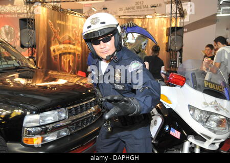 Ein Mann, gekleidet als Offizier der Polizei von Los Angeles stellt am Computer Spiele-Messe Gamescom in Köln, 21. August 2011. Europas größte Messe für interaktive Spiele und Unterhaltung erlebt Besucheransturm am letzten Wochenende, 20. bis 21. August 2011. 550 Aussteller präsentierten die Messe. Die Trendthemen wurden Online-Spiele und 3D-Spiele. Foto: Jan Knoff Stockfoto