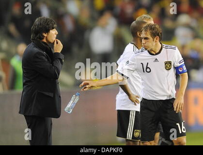 (Dpa-Datei) - ein Datei-Bild datiert 3. September 2010 der deutschen nationalen Fußball-Trainer Joachim Löw (L) stehen auf der Seitenlinie Nect, Spieler Philipp Lahm (R) Dduring das Spiel gegen Belgien in Brüssel, Belgien. Kurz vor den Spielen gegen Österreich, Polen sorgt Lahms kürzlich erschienenen Buch für Kontroversen. Nach seiner Medienzentrum, der deutschen Fußball-Bundes Stockfoto