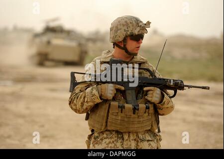 Ein Bundeswehr-Soldat streift durch die Wüste während einer Mission der Minenräumung in Kundus, Afghanistan, 26. August 2011. Die Bundeswehr ist immer wieder in Kampfhandlungen in Nordafghanistan verwickelt. Foto: MAURIZIO GAMBARINI Stockfoto