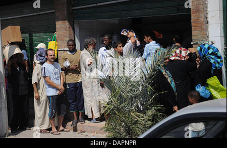 Menschen in die Warteschlange für Brot auf Sonntag, 28. August 2011 in einer Straße in Tripoli, Libyen. Libysche Rebellen Fragen Polizeibeamte aus arabischen Ländern, die Sicherheitslage in Libyen, der Anführer der libyschen Opposition Rat sagte am Samstag zu helfen. Foto: Hannibal Dpa +++(c) Dpa - Bildfunk +++ Stockfoto