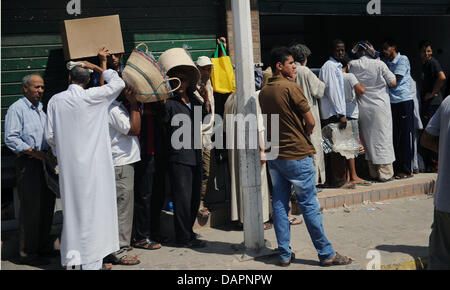 Menschen in die Warteschlange für Brot auf Sonntag, 28. August 2011 in einer Straße in Tripoli, Libyen. Libysche Rebellen Fragen Polizeibeamte aus arabischen Ländern, die Sicherheitslage in Libyen, der Anführer der libyschen Opposition Rat sagte am Samstag zu helfen. Foto: Hannibal Dpa +++(c) Dpa - Bildfunk +++ Stockfoto