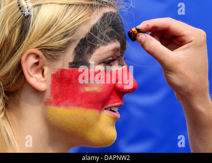 Zwei deutsche Fans malen ihre Gesichter in den deutschen Farben vor der Männern Rollstuhlbasketball Nations Championship final match Niederlande gegen Deutschland im Hockey-Park in Mönchengladbach, 28. August 2011. Foto: Roland Weihrauch Stockfoto