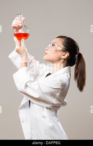 Weibliche chinesische Gesundheitswesen beruflichen oder wissenschaftlichen Forscher betrachten eine Reihe von Reagenzgläsern Stockfoto