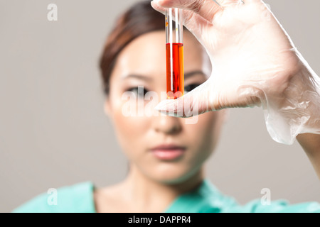 Chinesische Medizin berufliche oder wissenschaftliche Forscherin hält ein Reagenzglas Stockfoto