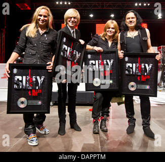 Die Mitglieder der Band Silly, Gitarrist Uwe Hassbecker (L-R), Keyboarder Ruediger Barton, Sängerin Anna Loos Abd Bassist Jaecki Reznicek präsentieren die Platin-Auszeichnung während eines Konzerts in Seebühne ("Seebuehne") in Magdeburg, Deutschland, 28. August 2011. Mit mehr als 200.000 verkauften CDs, das Comeback-Album "Alles rot" ging Platin. Die Ost-Rock-Band beendet seine 'alle rot'-tour nach zwei ye Stockfoto