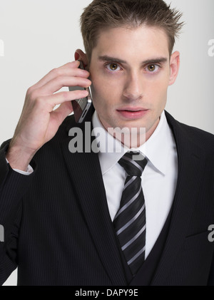 Geschäftsmann in Anzug und Krawatte mit einem Apple iPhone telefonieren Stockfoto