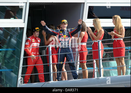 Deutsche Formel1-Fahrer Sebastian Vettel (C, Gewinner) von Red Bull und Spanisch Fernando Alonso (2-L, 3. Platz) von Ferrari auf ihrem Weg auf das Podium des italienischen GP auf der Rennstrecke Autodromo Nazionale Monza, Italien, 11. September 2011 zu feiern. Die Formel 1 Grand Prix von Italien ist der letzten Europa-Rennen der Saison 2011. Foto: David Ebener dpa Stockfoto