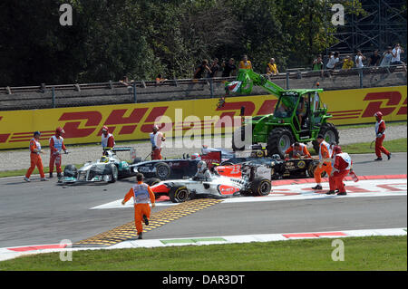 Marschälle haben mehrere Auto Kollision nach dem Start des italienischen GP auf der Rennstrecke Autodromo Nazionale Monza, Italien, 11. September 2011 zu bereinigen, nachdem. Die Formel 1 Grand Prix von Italien ist der letzten Europa-Rennen der Saison 2011. Foto: David Ebener dpa Stockfoto