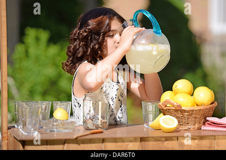 kleines Mädchen trinken von Limonade Krug Stockfoto