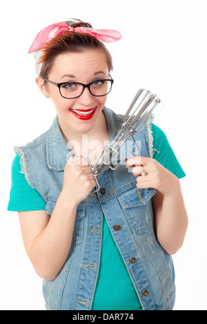 Teenager-Mädchen, lässig gekleidet und tragen einer Brille, macht albern, lustige Gesichter halten Sie einen Ei Rührbesen Mixer. Stockfoto