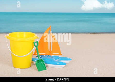 Spielzeug Segelboot und des Kindes Eimer am Strand Stockfoto
