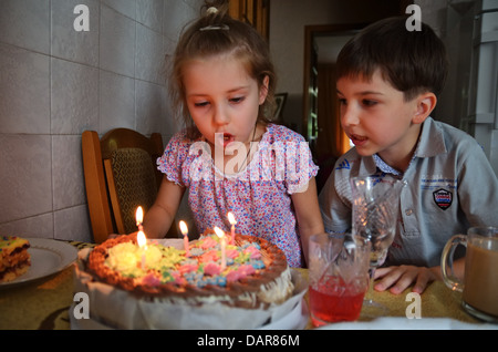 Kinder Ausblasen der Kerzen auf der Geburtstagstorte, Ukraine Stockfoto