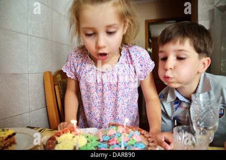 Kinder Ausblasen der Kerzen auf der Geburtstagstorte, Ukraine Stockfoto