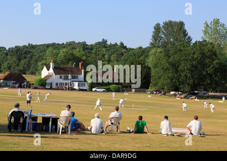 Lokale Team spielen Cricket Match auf Village Green vor der Gerste Mähen Pub an einem Sommerabend. Tilford Surrey England Großbritannien Großbritannien Stockfoto