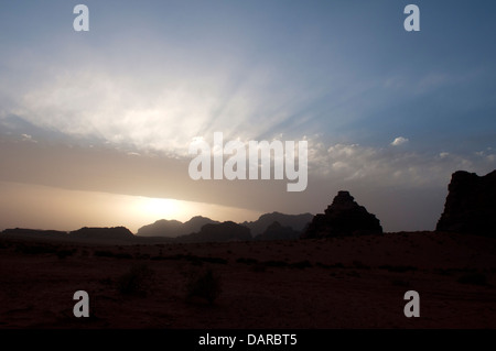Sonnenstrahlen über silhouettierten Felsformationen, Wüstendorf Wadi Rum, Jordanien Stockfoto