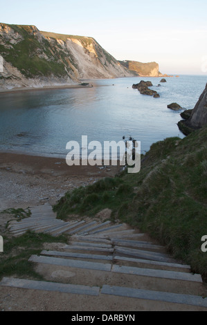 Schritte hinunter zum Strand an der Bucht von St. Oswald an der Jurassic Coast. In der Ferne sind die Kreidefelsen und das Geröll der jüngsten Erdrutsch. Dorset, UK. Stockfoto